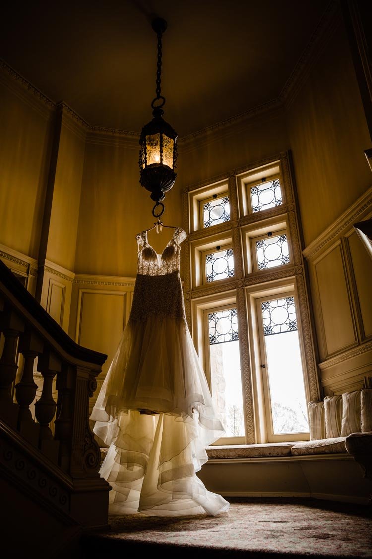 brides dress hanging in window at cairnwood estate