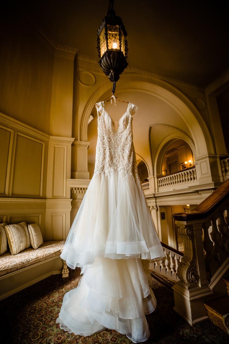 brides dress hanging in window at cairnwood estate